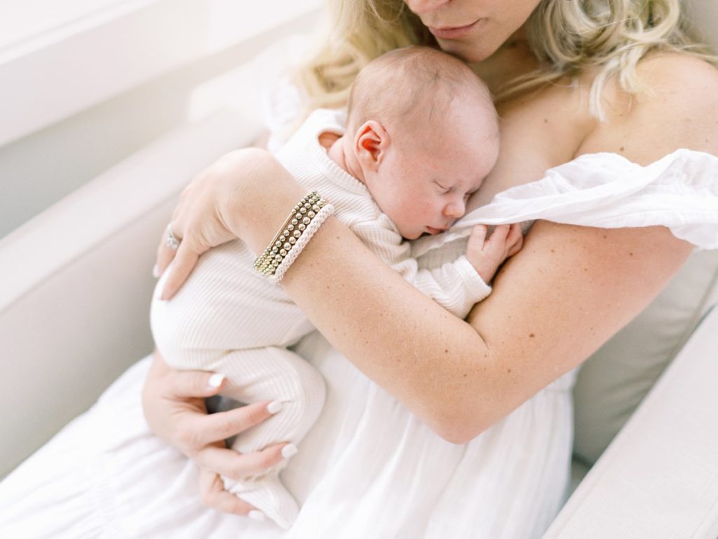 Mama cuddles with newborn during in home newborn session in Franklin