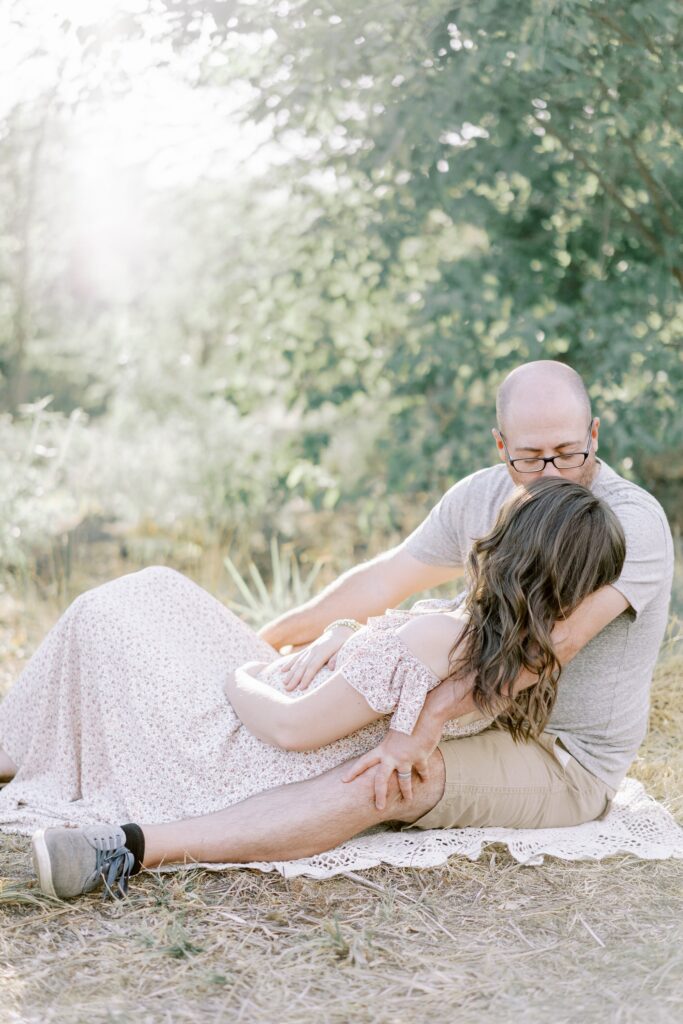 A husband kissing his expecting wife's forehead during a nashville outdoor maternity session
