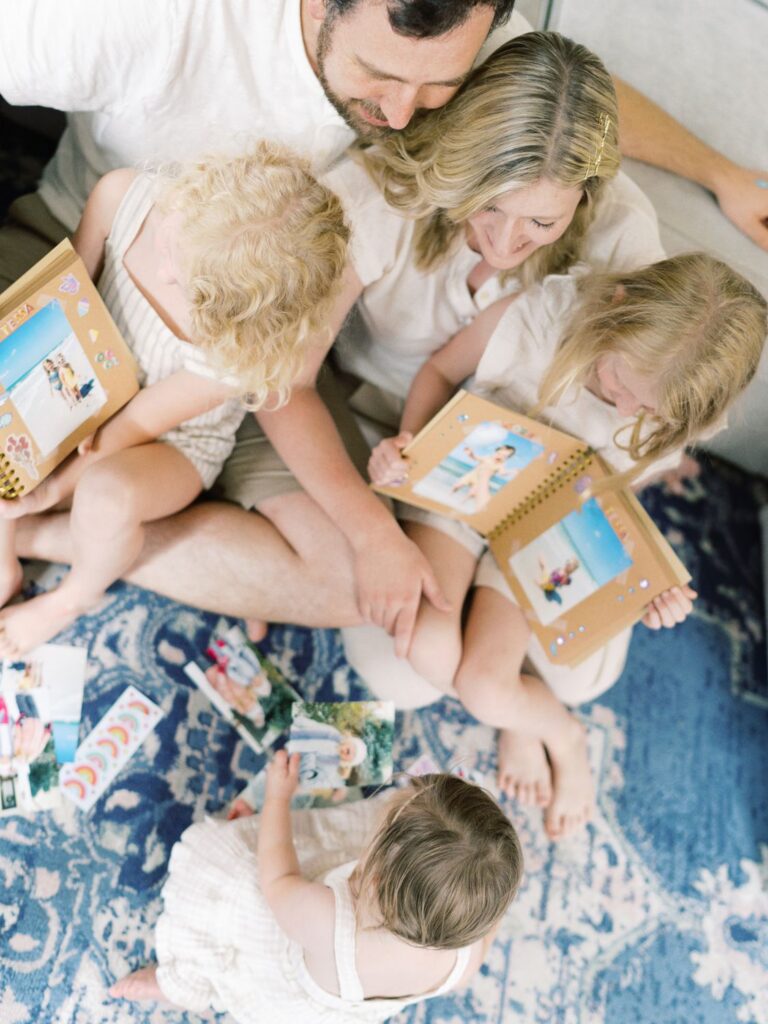 Courtney Houk Photography captures a family of five sitting on living room floor reading books during this Franklin TN in-home family session