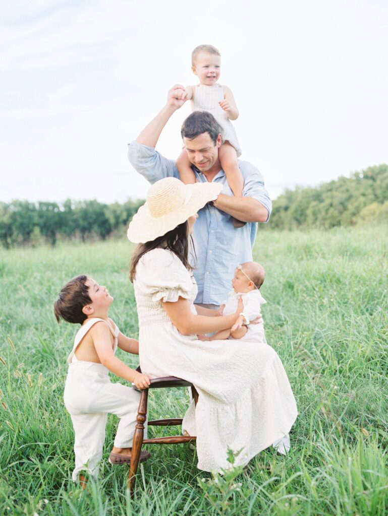 Courtney Houk Photography a Nashville family photographer captures a photo of a family of five in an open grassy field