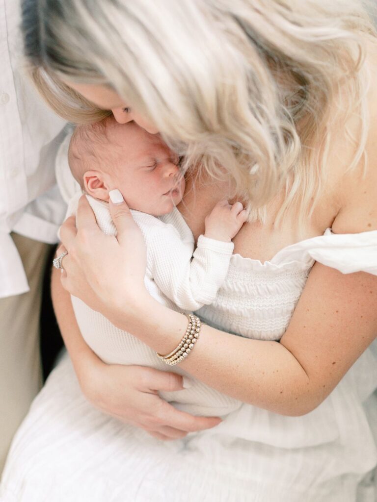This blog post by Nashville motherhood photographer Courtney Houk features a list of 7 best podcasts for moms and a 
photo of a mama cuddling here newborn baby boy