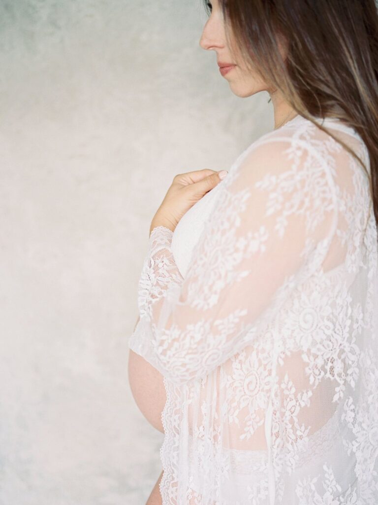 Nashville maternity photographer Courtney Houk captures a photo of a pregnant mama with a white lace over shirt on