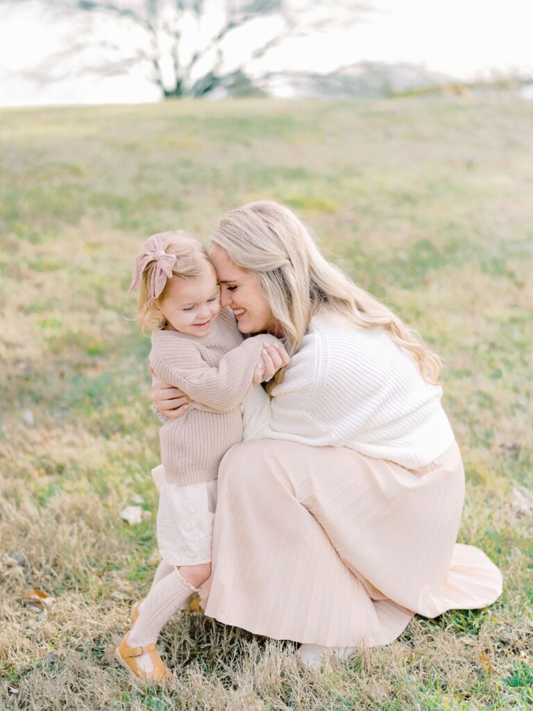 a woman and child sitting on grass